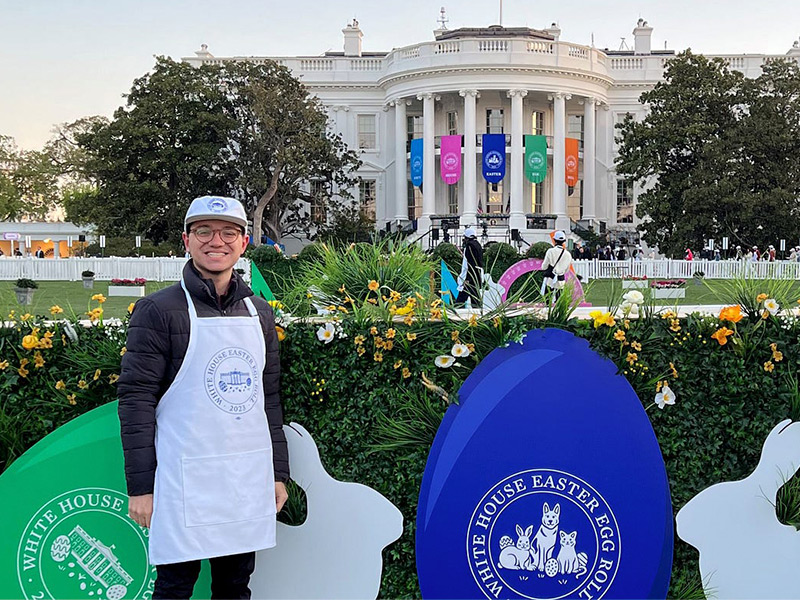 The first U.S. Digital Service intern, Sam, is standing in front of a U.S. government building.